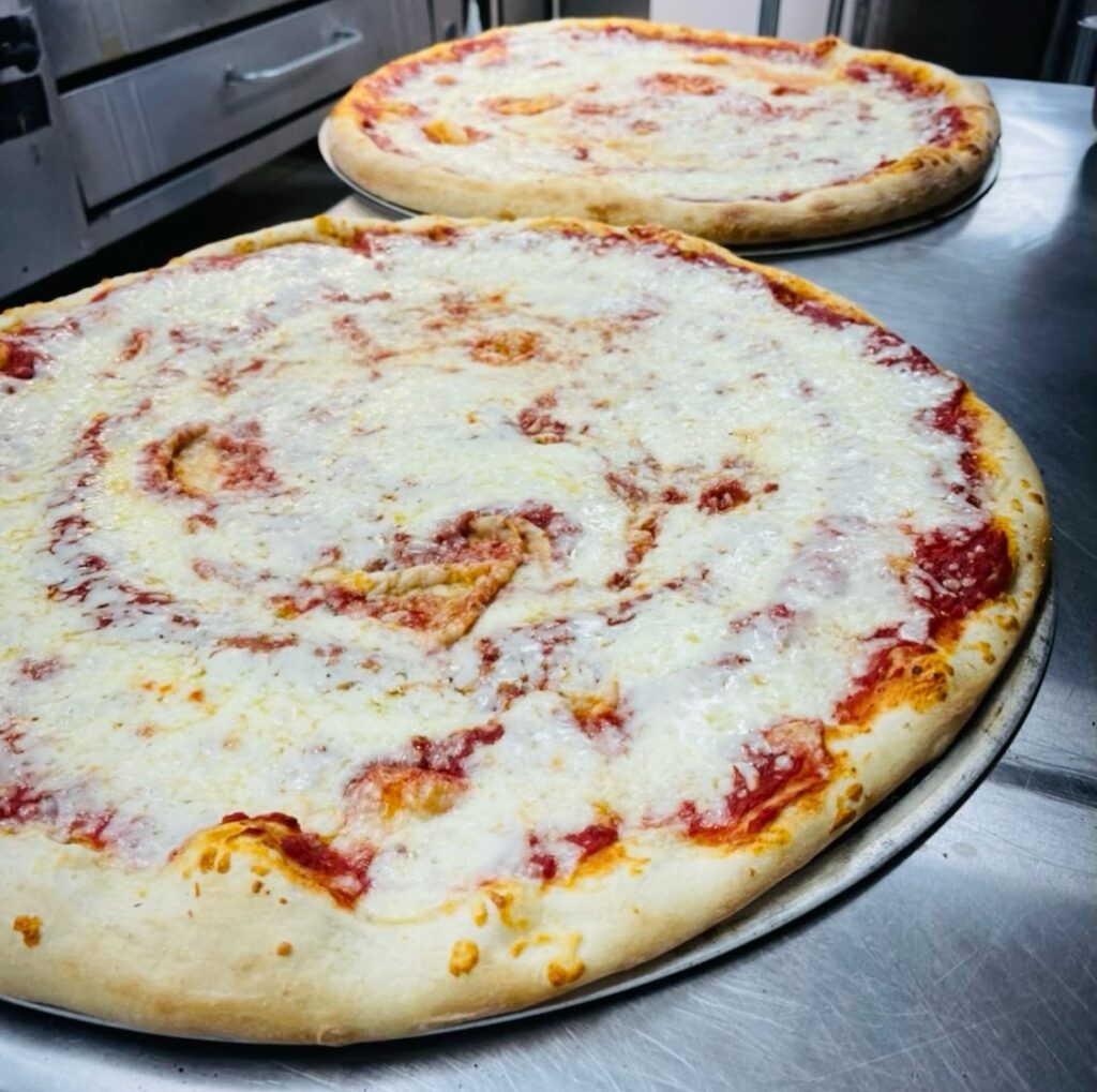 XXL Cheese pizzas are cut into slices and served as a lunch special for a low price.