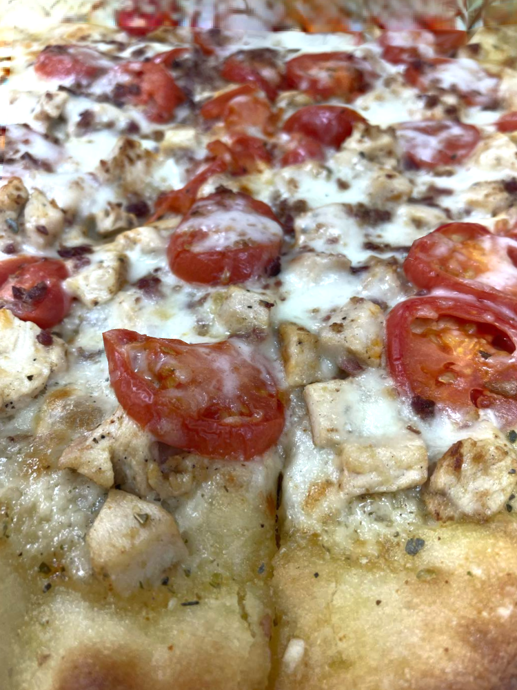 Closeup of AFP Special, includes chicken, cheese, tomato, and ranch dressing.